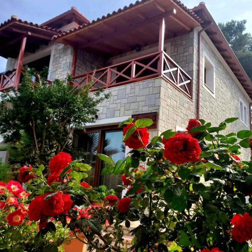 a house with red flowers in front of it at Villa Kristiano 21 in Sarandë