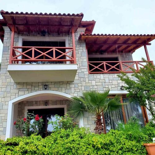 a building with a balcony and a palm tree at Villa Kristiano 21 in Sarandë