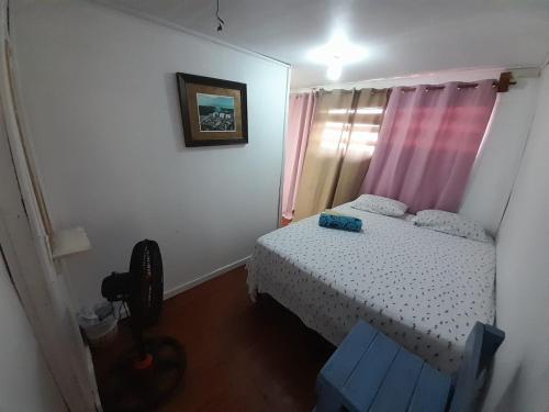 a small bedroom with a bed and a blue chair at Hotel Victoria s Beach House in Roatan