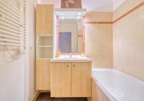 La salle de bains est pourvue d'un lavabo, d'une baignoire et d'un miroir. dans l'établissement RARE Terrasse, Parking, proche Orly, Scène nationale 10 mn à pieds RER D, à Courcouronnes