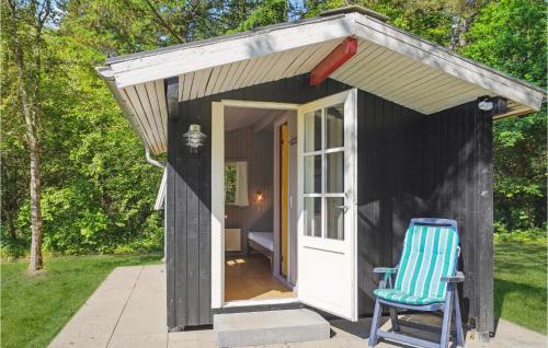 a small black shed with a blue chair in front of it at Gorgeous Home In Ans By With Wifi in Roe