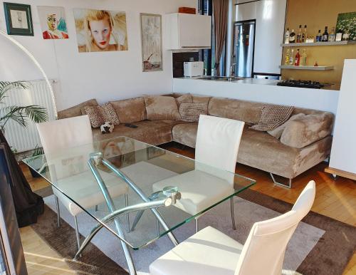 a living room with a glass table and white chairs at Bella Vista Lux Apartment with private Terace in Koper