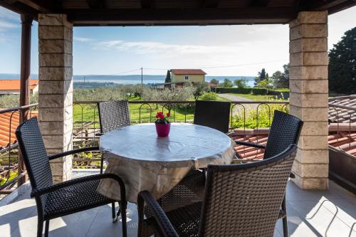 a table on a porch with chairs and a view at Apartments and Rooms Ješelnik in Portorož