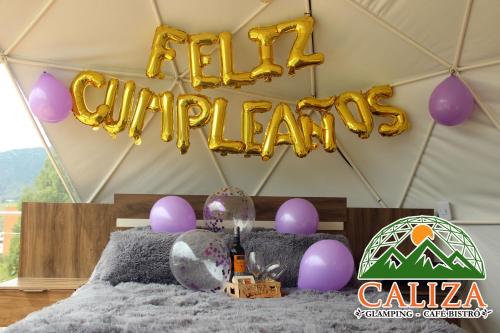 a tent with purple balloons and a happy birthday sign at Glamping Caliza La Calera in La Calera
