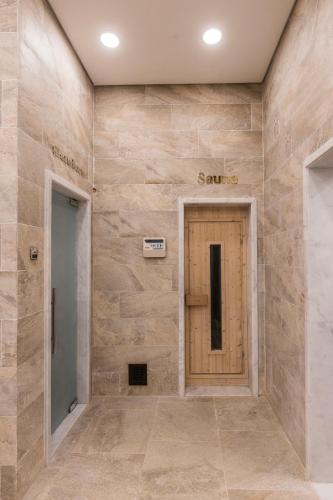 a hallway with a wooden door in a stone wall at Gewan White Beach Resort-New Alamein in Marsa Matruh