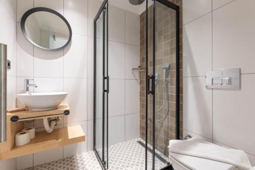 a bathroom with a glass shower and a sink at Bronze Hotel in Oludeniz