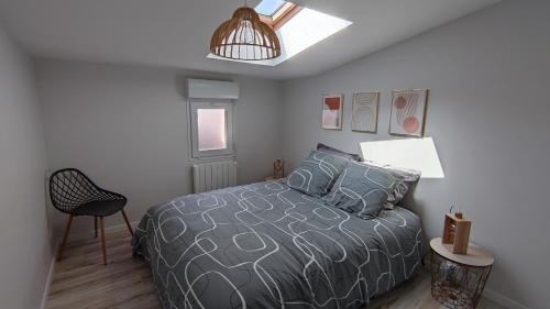 une chambre avec un lit et une chaise dans l'établissement Maison de ville 600 m du Marché, à La Rochelle