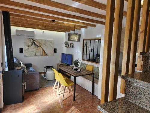 sala de estar con escritorio y sillas amarillas en El Rincón de Mariela by Travel Home, en Segura de la Sierra