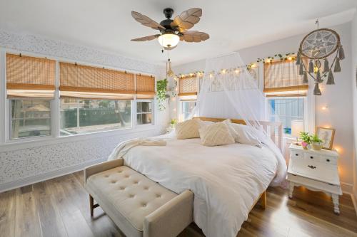 a bedroom with a bed with a ceiling fan and windows at Little “house” right on the beach in Hollywood