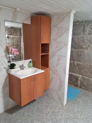 La salle de bains est pourvue d'un lavabo et d'un miroir. dans l'établissement Charmigt hus på landet nära till bad, à Strömstad