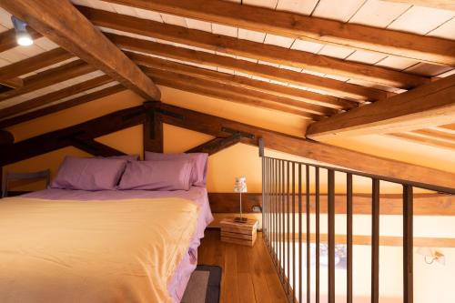 a bedroom with a bed in a room with wooden ceilings at Casale del Rosmarino - Suite Albicocca in Montefiascone