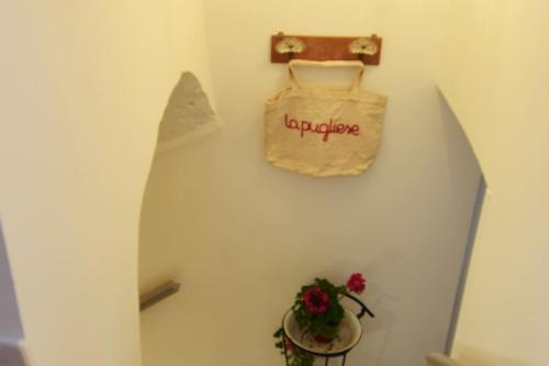 un sac suspendu sur un mur à côté d'une table dans l'établissement La Biancasa, à Carovigno