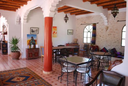 un soggiorno con tavoli e sedie in un edificio di Riad Titima Essaouira a Essaouira