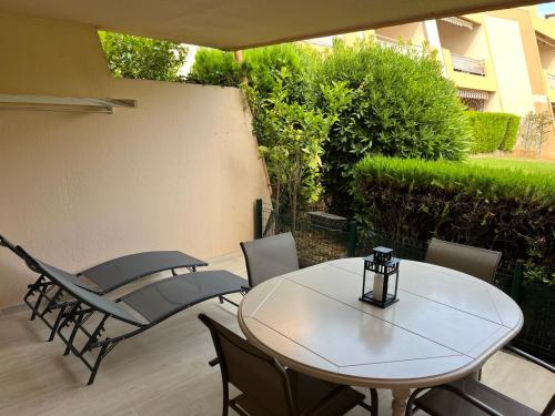 un patio con mesa y sillas en Appartement Le Pradet - Résidence Piscine Tennis Bord de Mer - Bertrand Béatrice, en Le Pradet