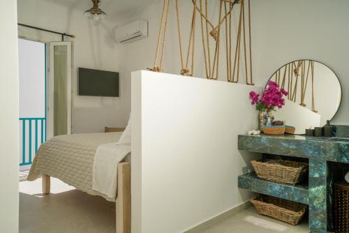 a bedroom with a bed and a mirror at Seabed Suites Mykonos in Mýkonos City