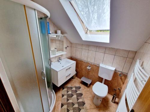 une salle de bain avec toilettes, lavabo et fenêtre dans l'établissement House Ana, aux lacs de Plitvice