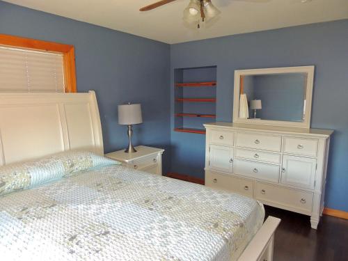 a bedroom with a bed and a dresser and a mirror at Angel Rock Waterfront Cottages in Cape Vincent