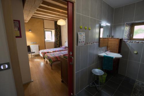 une salle de bains avec lavabo et une chambre avec lits dans l'établissement la grange, à Pouligny-Saint-Pierre