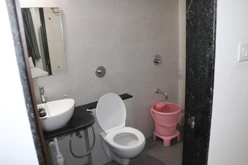 a bathroom with a toilet and a sink at Ornate Service Apartments in Pune