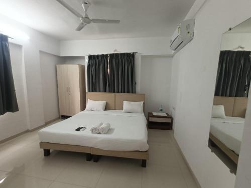 een slaapkamer met een bed met twee handdoeken erop bij Ornate Service Apartments in Pune
