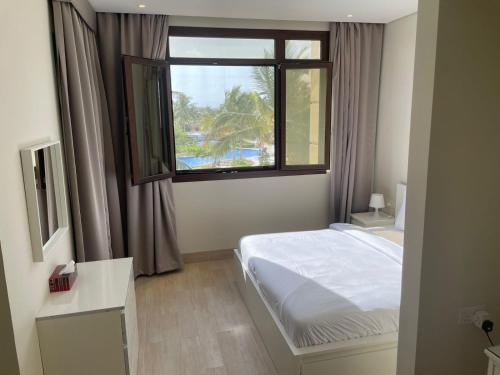 - une chambre avec un lit et une grande fenêtre dans l'établissement Hawana Forest Island Salalah, à Ma‘mūrah