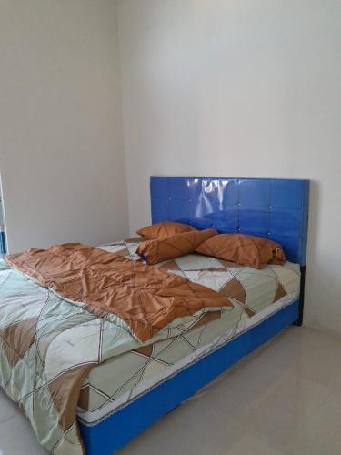 a bed with a blue headboard in a room at Muja house villa in Praya