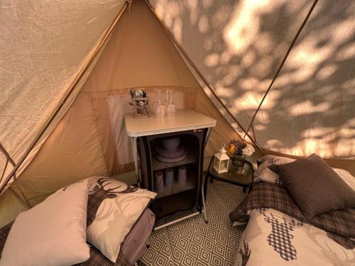 a tent with two beds and a table in it at Superior Luxury Large Emperor Tent in Stoke Goldington