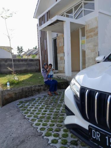 a woman and a child standing outside of a house at Muja house villa in Praya