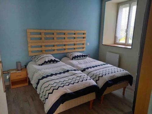 2 camas en un dormitorio con paredes azules en Gîte 5-6 personnes « Chez Marlène »proche de Nigloland en Meurville