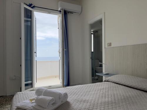 a bedroom with a bed and a large window at Hotel Castelsardo Domus Beach in Castelsardo