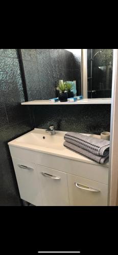 une salle de bain avec un lavabo blanc et une fenêtre dans l'établissement Appartement 100 m de la plage, à Saint-Palais-sur-Mer