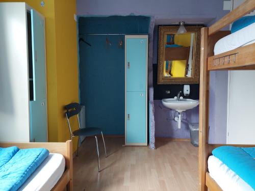 a room with two bunk beds and a sink at Oldtown Hostel Otter in Zürich