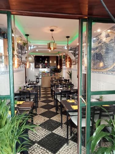 a restaurant with black tables and green columns at Sylhet BNB in Lisbon