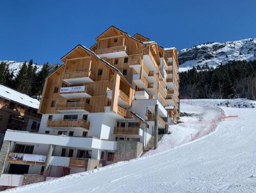 un grand bâtiment dans la neige dans l'établissement L'orée des pistes, à Oz