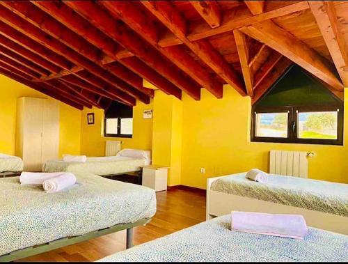 a room with four beds in a room with yellow walls at Villa Arboleda in La Losa