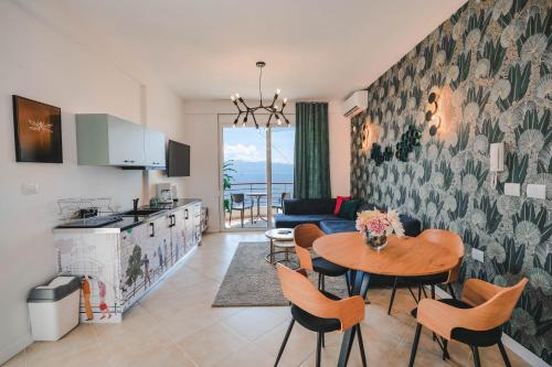 a kitchen and a living room with a table and chairs at Sunny Apts in Sarandë