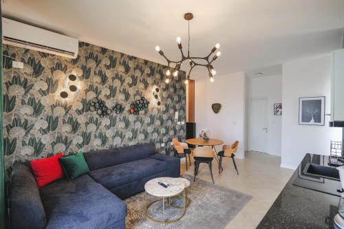 a living room with a blue couch and a table at Sunny Apts in Sarandë