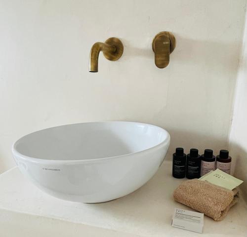 a white bowl on a counter with a sink at Mykonian Starling - Town n' Sunset View Apartment in Mýkonos City