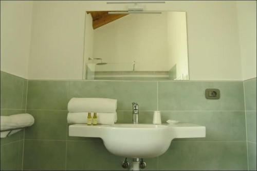 y baño con lavabo blanco y espejo. en Casa Margarina - Self catering apartment en Saluzzo