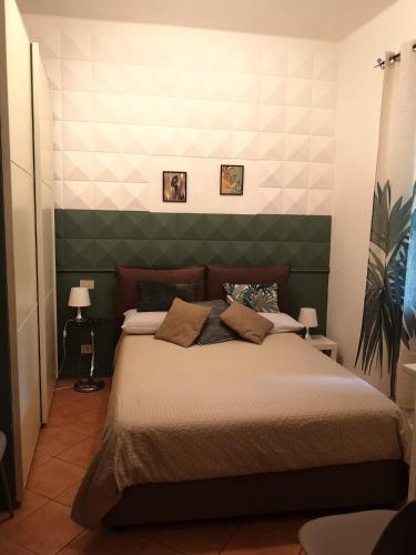 Schlafzimmer mit einem großen Bett mit einem grünen Kopfteil in der Unterkunft Casa Ludo in Lucca