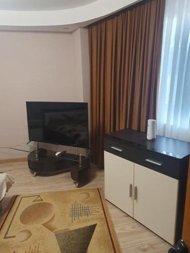 uma sala de estar com uma televisão de ecrã plano e uma cómoda em Casa Marco em Galaţi