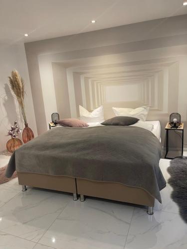 a bedroom with a large bed with a gray blanket at Moderne, ruhige Ferienwohnung in der Stadtmitte in Hadamar