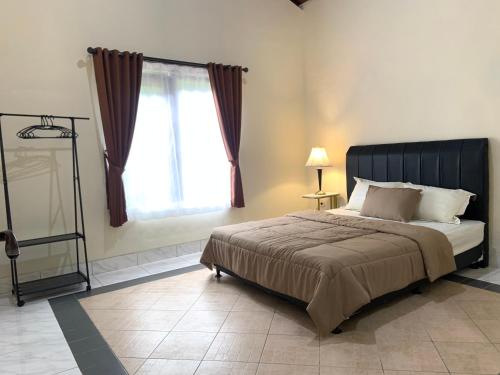 Sampal 2的住宿－Villa Kay Hills，一间卧室设有一张大床和一个窗户。