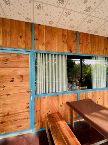 a room with wooden walls and a table and a window at Bến Hồ Homestay in Xã Gia Tân