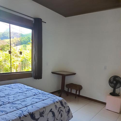 Un dormitorio con una cama y una ventana y un escritorio. en Casa Lumiar, en Lumiar