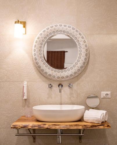 a bathroom with a sink and a mirror on the wall at Amelia Apts & Rooms in Alghero