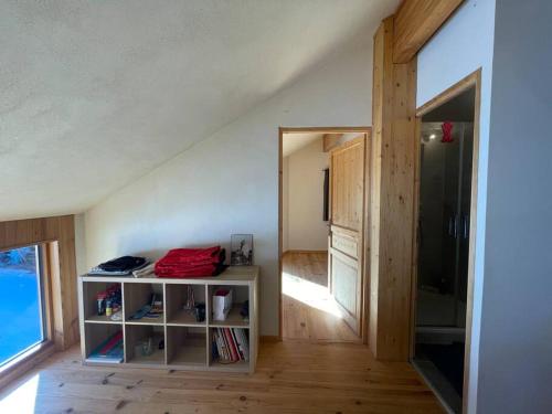 a room with a book shelf next to a door at Chalet - Chambre de Francesco - 2 lits superposés in Briançon
