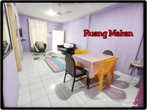 uma sala de estar com uma mesa de jantar e cadeiras em Arjuwani Homestay Gua Musang em Gua Musang