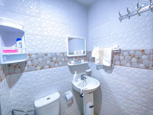 La salle de bains est pourvue de toilettes blanches et d'un lavabo. dans l'établissement Your new home, à Oujda