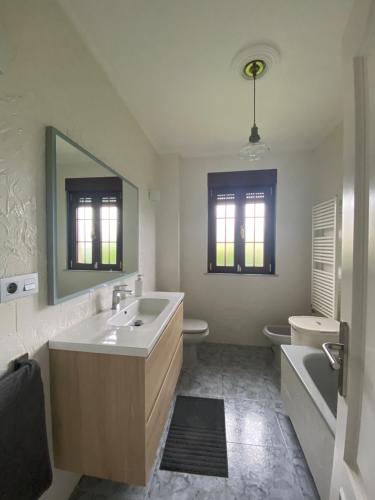 a bathroom with a sink and a toilet and a mirror at Chalet en Suances in Ongayo